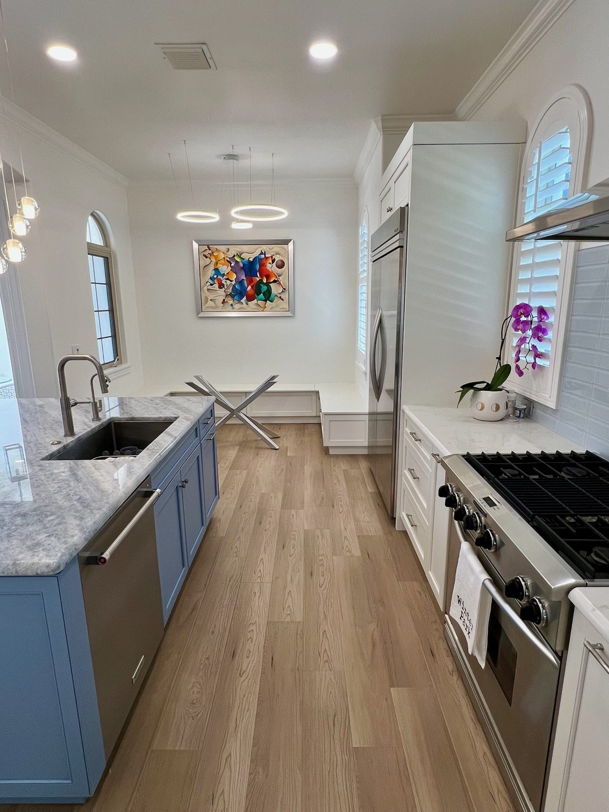 Galley run with quartzite counters, gas range, and white oak floors