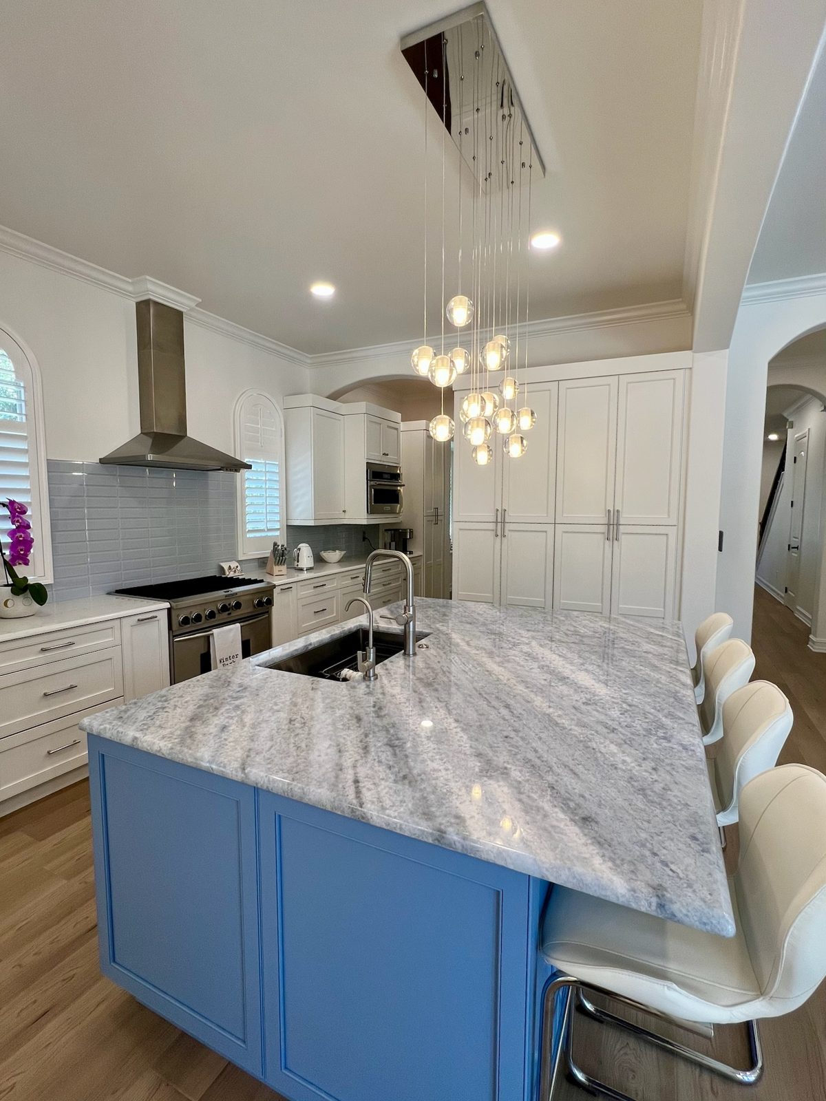 Blue island kitchen with stainless hood and custom white cabinetry