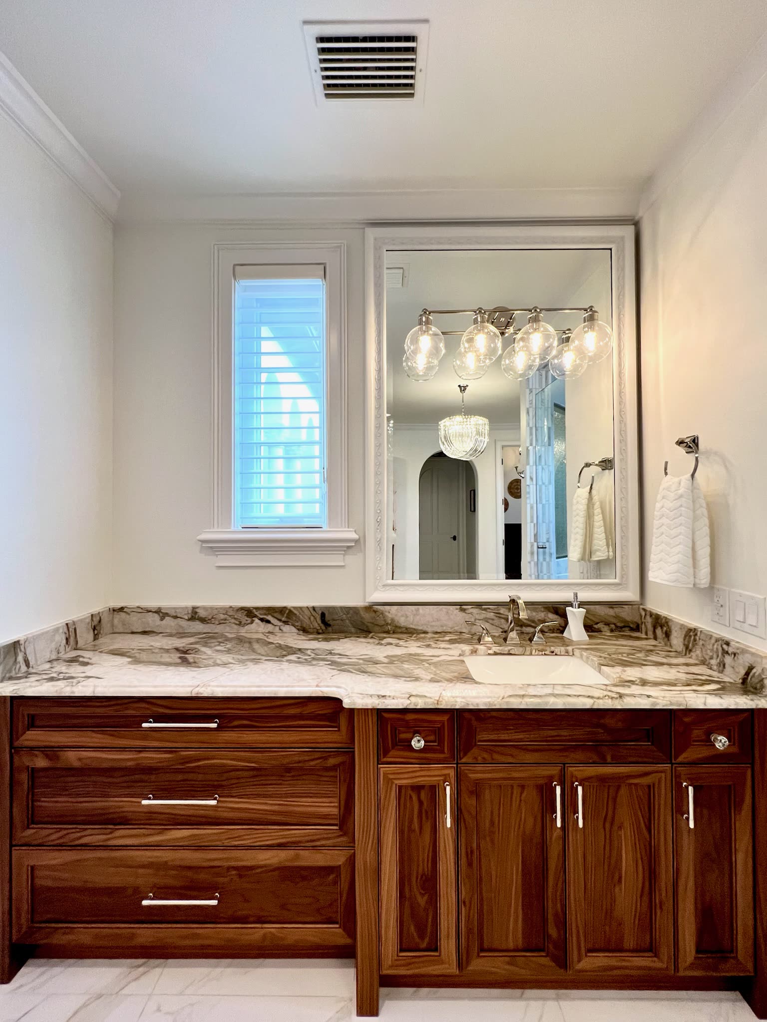 Walnut vanity with framed mirror and sconces