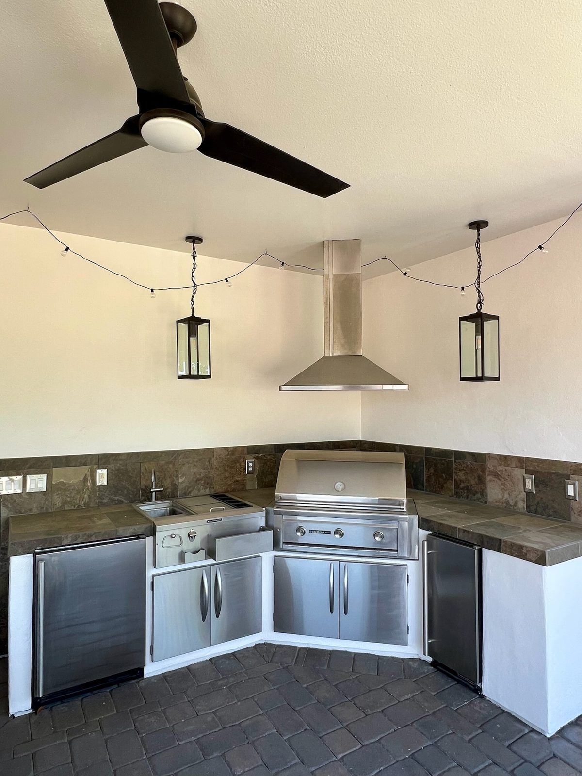 Covered outdoor kitchen with built-in grill and stone counters