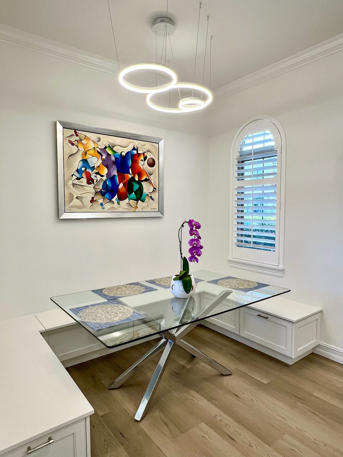 Breakfast nook with glass table and ring pendant lighting