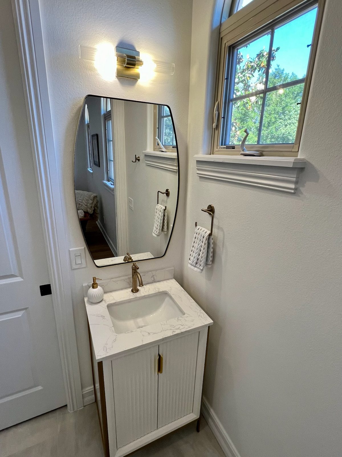 Guest bath vanity beneath a bright corner window