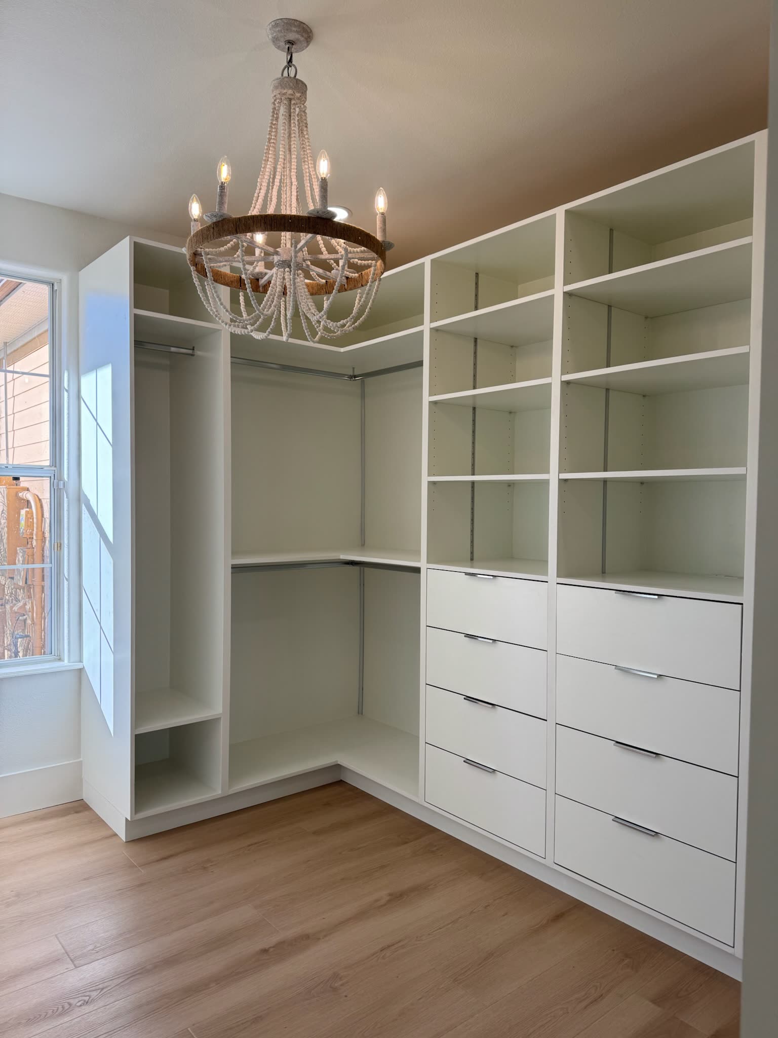 Custom walk-in closet with open shelving and a drawer bank