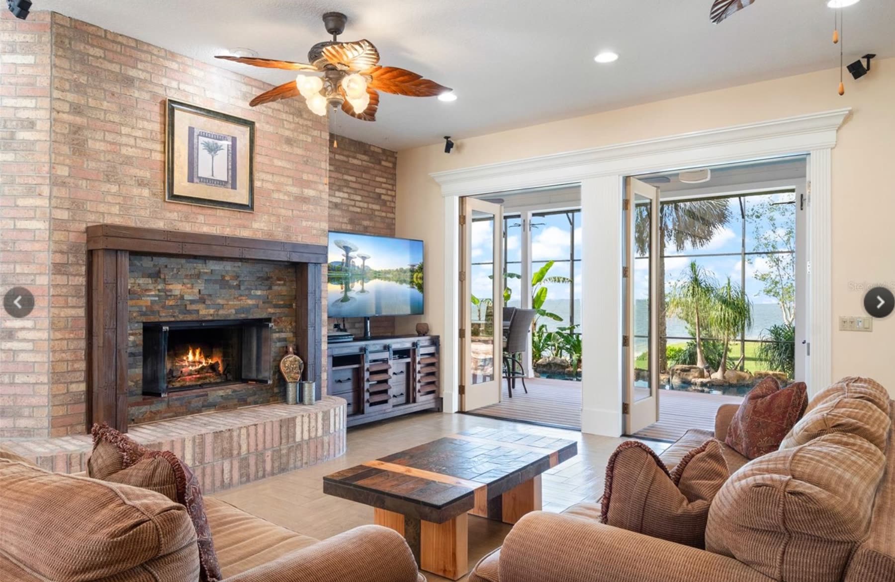 Living room with brick fireplace and dated built-ins before renovation