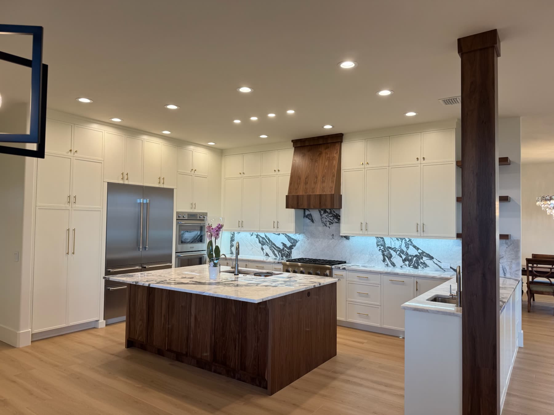 Renovated white kitchen with walnut island and marble backsplash